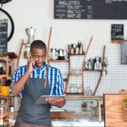 Small Business Owner on the Phone while looking at Tablet